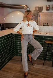 Chemise fleurie à manches longues portée par une femme, silhouette entière, comptoir, escarpins
