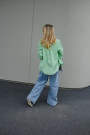 Chemise à carreaux boutonnée portée par une femme, vue de dos, silhouette entière