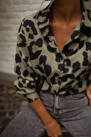 Chemise léopard légèrement ample portée par une femme, vue rapprochée, motif léopard, col