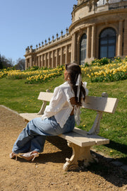 Chemise à dos ouvert volanté portée par une femme, assise, banc, parc
