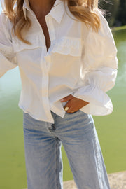 Chemise à dos ouvert volanté portée par une femme, vue rapprochée, poches poitrine, jean