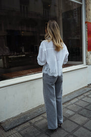 Chemise courte à dentelle portée par une femme, vue de dos, vitrine, jean gris