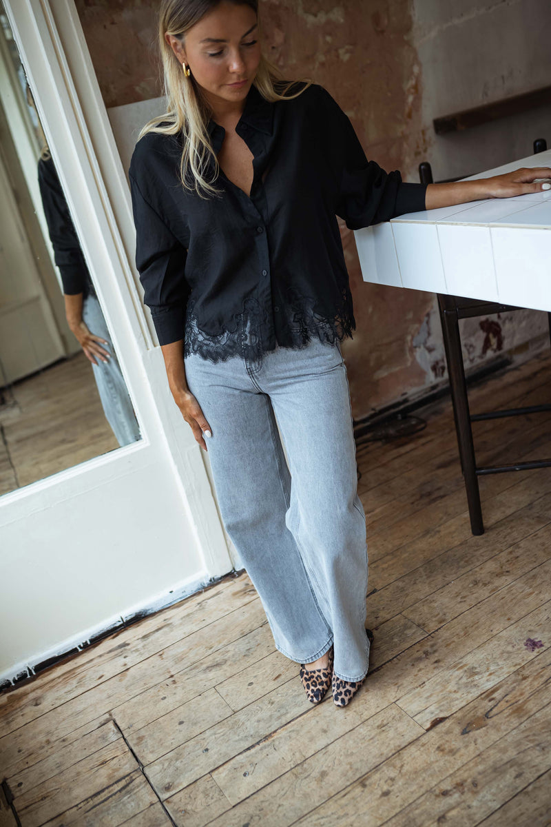 Chemise à dentelle transparente portée par une femme, vue de face, café, comptoir blanc