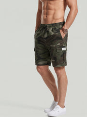 Short camouflage à poches — vert camouflage porté de face, mains dans les poches