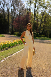 Combinaison longue dos ouvert jaune portée par une femme, silhouette entière, tulipes, de face