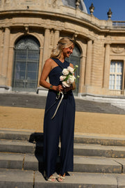 Combinaison longue croisée dos ouvert portée par une femme, silhouette entière, escalier, bouquet