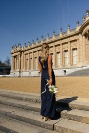 Combinaison longue croisée dos ouvert portée par une femme, silhouette entière, façade, escalier