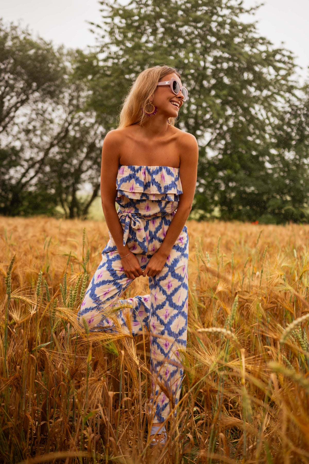 Combinaison bustier à pantalon long portée par une femme, vue de face, champ de blé, bustier