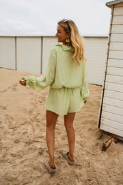 Combishort à volants boutonné porté par une femme, silhouette entière, sable, cabines