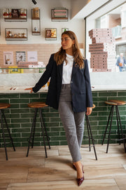 Blazer long doublé ample bleu porté par une femme, silhouette entière, bar, tabourets