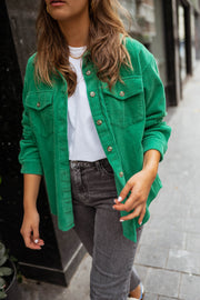 Surchemise fluide en velours verte portée par une femme, vue rapprochée, poches, t-shirt blanc