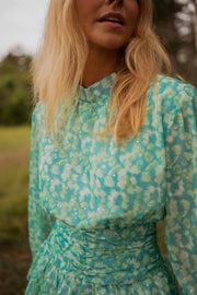 Robe fluide à motifs argentés portée par une femme, vue rapprochée, col, motif