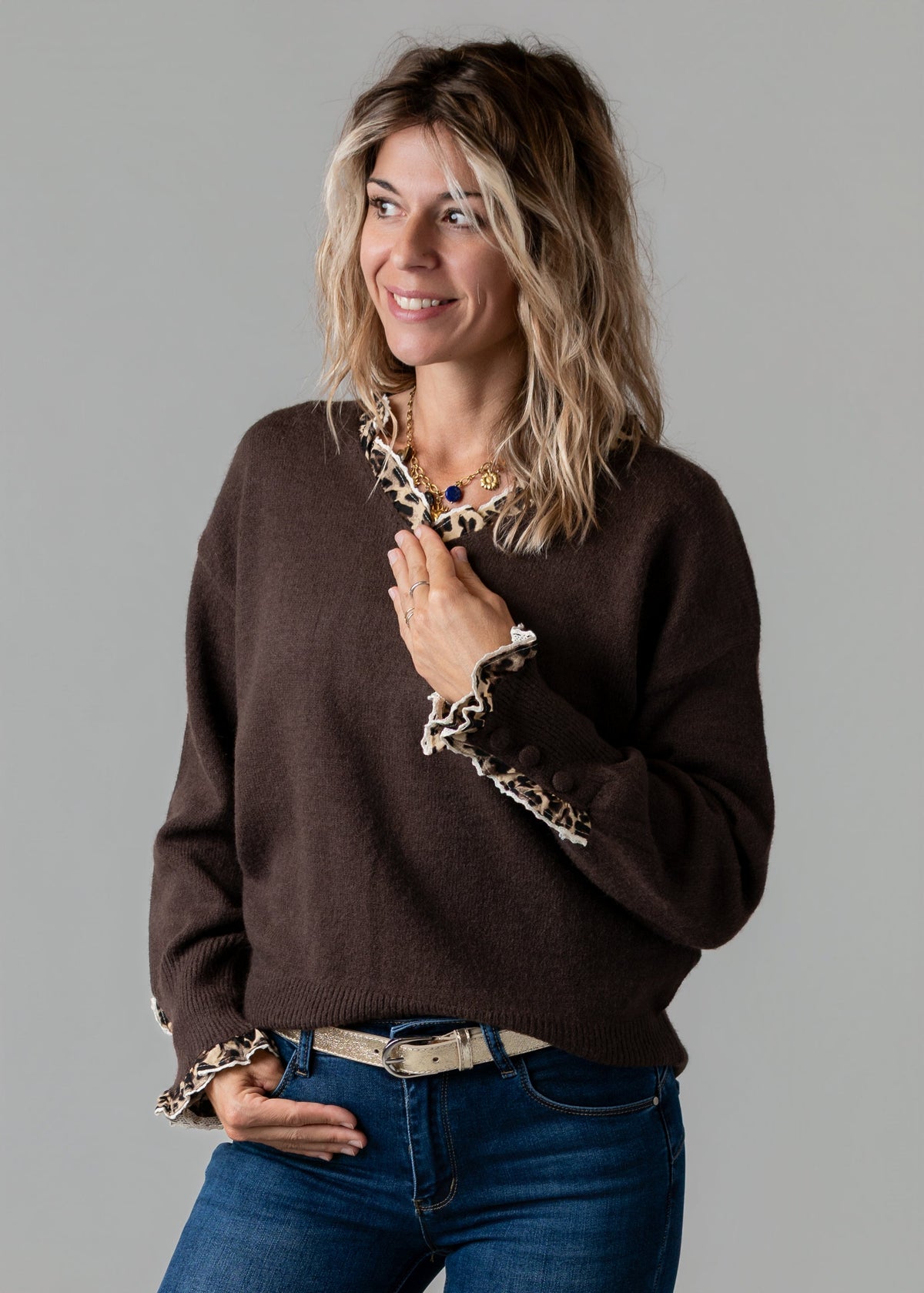 Pull col V léopard porté par une femme, vue rapprochée, ceinture, col V, bordure léopard