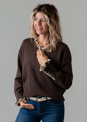 Pull col V léopard porté par une femme, vue rapprochée, ceinture, col V, bordure léopard