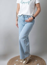 Jean large taille haute stretch porté par une femme, vue de trois-quarts, jean large, mains dans les poches