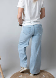 Jean large taille haute stretch porté par une femme, vue de dos, jean large, baskets