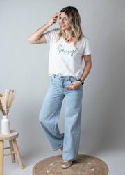 Jean large taille haute stretch porté par une femme, vue de trois-quarts, main dans la poche