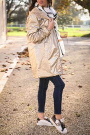 Parka réversible fourrure portée par une femme, silhouette entière, côté doré, allée