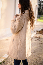 Parka réversible fourrure portée par une femme, vue de dos, côté fourrure beige, allée