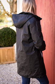 Parka réversible à fourrure portée par une femme, vue de dos, capuche, jardin