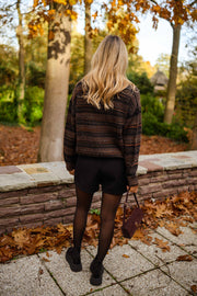 Gilet rayé col rond marron porté par une femme, vue de dos, feuilles d'automne, jupe noire