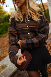 Gilet rayé col rond marron porté par une femme, vue rapprochée, rayures marron, pochette bordeaux