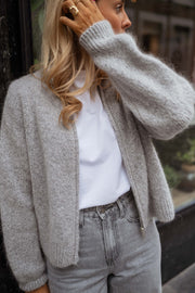 Gilet court à col rond gris porté par une femme, vue rapprochée, gilet gris, t-shirt blanc