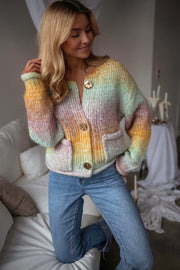 Gilet en maille tie-dye porté par une femme, vue rapprochée, dégradé arc-en-ciel, boutons