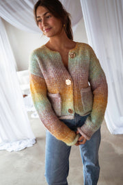 Gilet en maille tie-dye porté par une femme, vue de face, poches plaquées, jean bleu