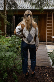 Gilet jacquard à col rond porté par une femme, vue de dos, cabane en bois, échelle