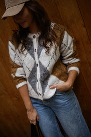 Gilet jacquard à col rond porté par une femme, vue rapprochée, losanges, casquette