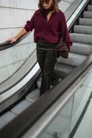 Gilet doux chaud à boutons bordeaux porté par une femme, en marchant, escalier mécanique, sac marron