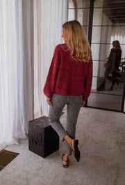 Gilet chiné boutonné bordeaux porté par une femme, vue de dos, cube noir, cheveux blonds