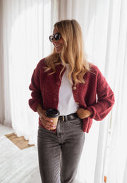 Gilet chiné boutonné bordeaux porté par une femme, vue de face, gobelet, lunettes