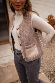 Gilet effet mouton et daim taupe porté par une femme, vue rapprochée, poche, daim