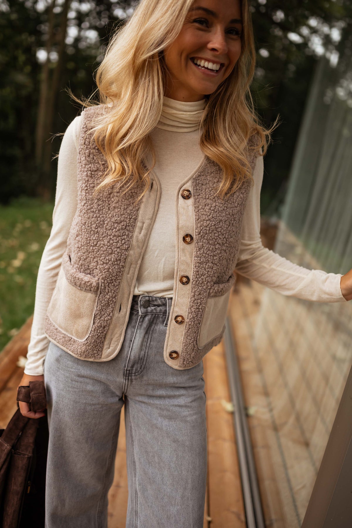 Gilet effet mouton et daim taupe porté par une femme, vue de face, col roulé blanc, gilet