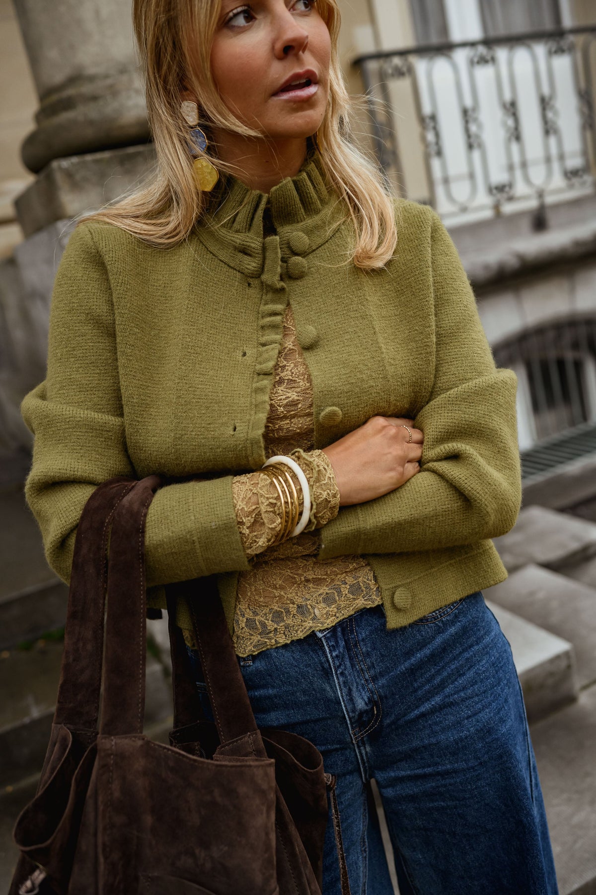 Gilet à col victorien porté par une femme, vue de trois-quarts, sac marron, bracelets