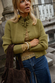 Gilet à col victorien porté par une femme, vue de trois-quarts, sac marron, bracelets