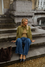 Gilet à col victorien porté par une femme, assise, marches, sac