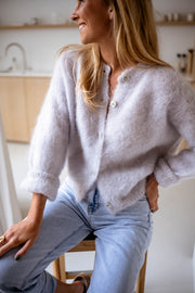 Gilet en kid mohair gris porté par une femme, vue de trois-quarts, cuisine, jean bleu