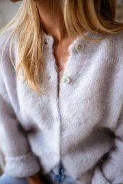 Gilet en kid mohair gris porté par une femme, vue rapprochée, boutons, maille douce