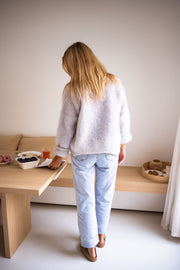 Gilet en kid mohair gris porté par une femme, vue de trois-quarts, table en bois, jean clair