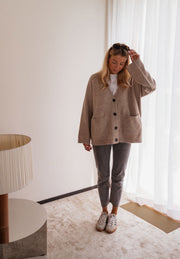 Gilet long droit à poches beige porté par une femme, vue de face, lunettes, lampe