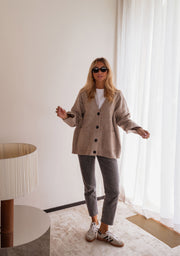 Gilet long droit à poches beige porté par une femme, vue de face, lunettes, lampe, autre cadrage