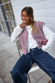Gilet sans manches à poches porté par une femme, vue de trois-quarts, sourire, jean foncé