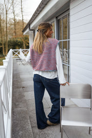 Gilet sans manches à poches porté par une femme, vue de dos, balcon, rambarde