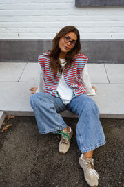 Gilet sans manches à poches porté par une femme, assise, terrasse, baskets