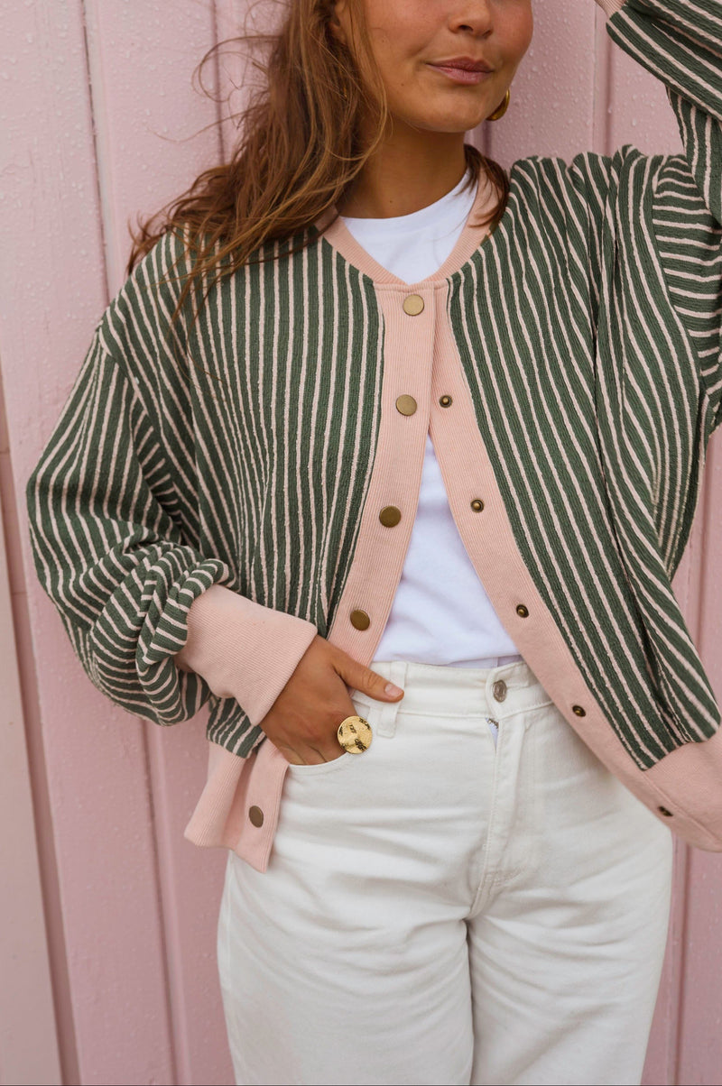 Gilet éponge rayé à pressions porté par une femme, vue rapprochée, t-shirt blanc, pantalon blanc