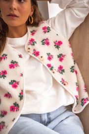 Gilet fleuri effet mouton porté par une femme, vue rapprochée, roses roses, col