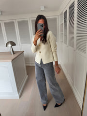 Blouse moulante à boutons dorés écrue portée par une femme, silhouette entière, selfie au miroir, jean gris